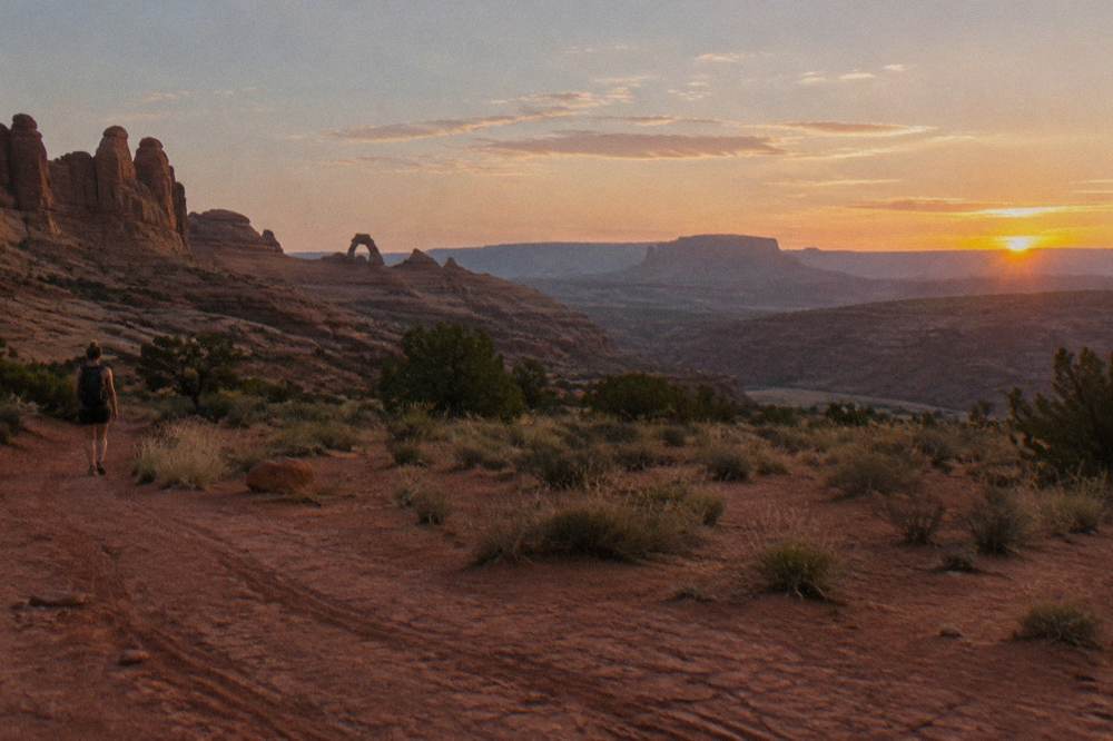 Wide desert horizon near Moab with layered mesas fading into evening haze