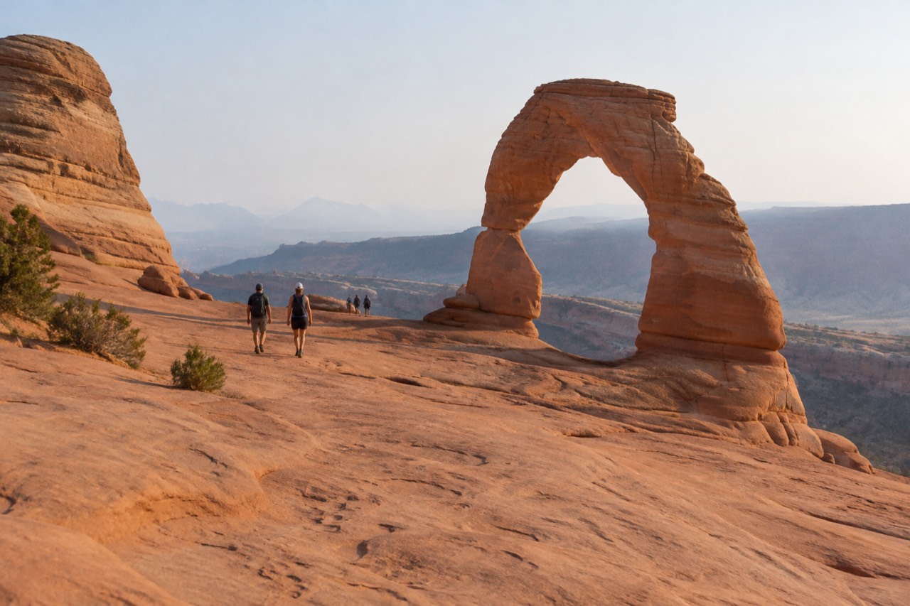A tall freestanding sandstone arch framed against an open desert sky at Arches National Park