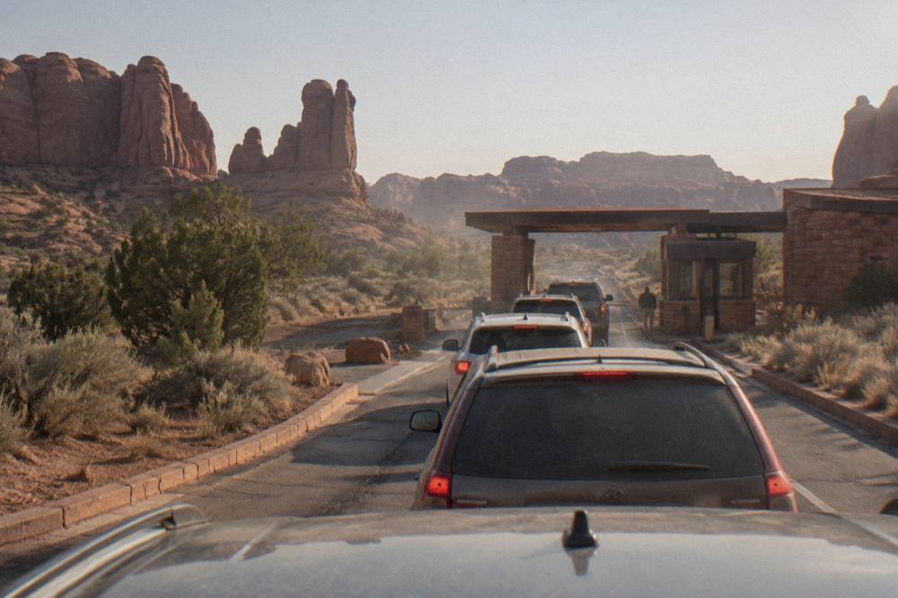 Line of cars waiting at the Arches National Park entrance station in late morning