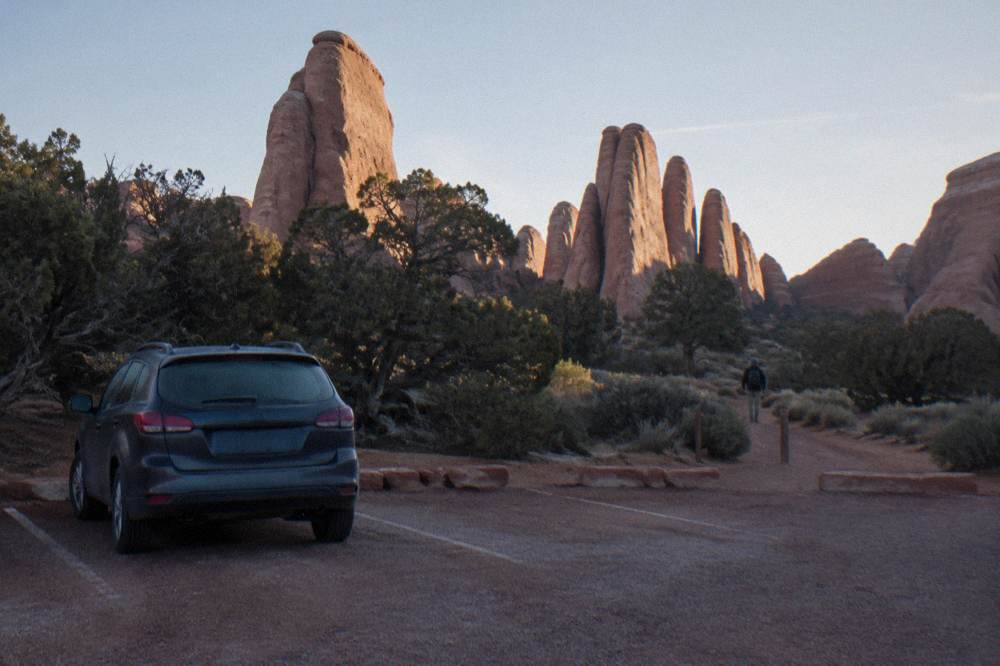 Golden light striking tall sandstone fins above a quiet desert turnout