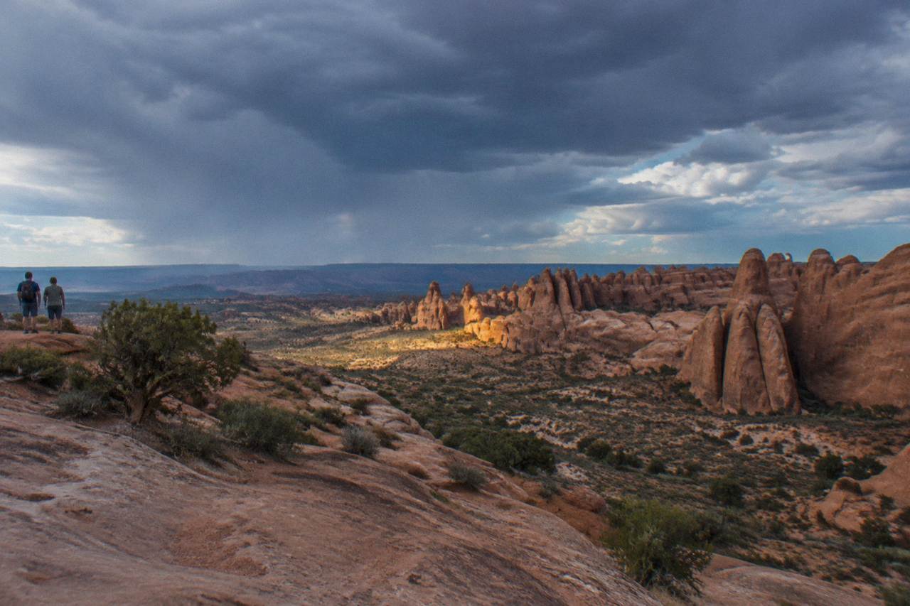 Wide desert view of layered canyon walls and sandstone formations under an open sky