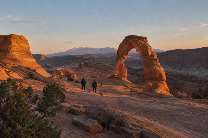 Sunset light on Balanced Rock and red rock towers seen from the park road in Arches National Park