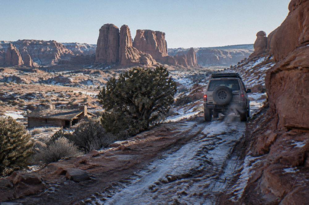 Four wheel drive vehicle on a rocky dirt track between sandstone walls