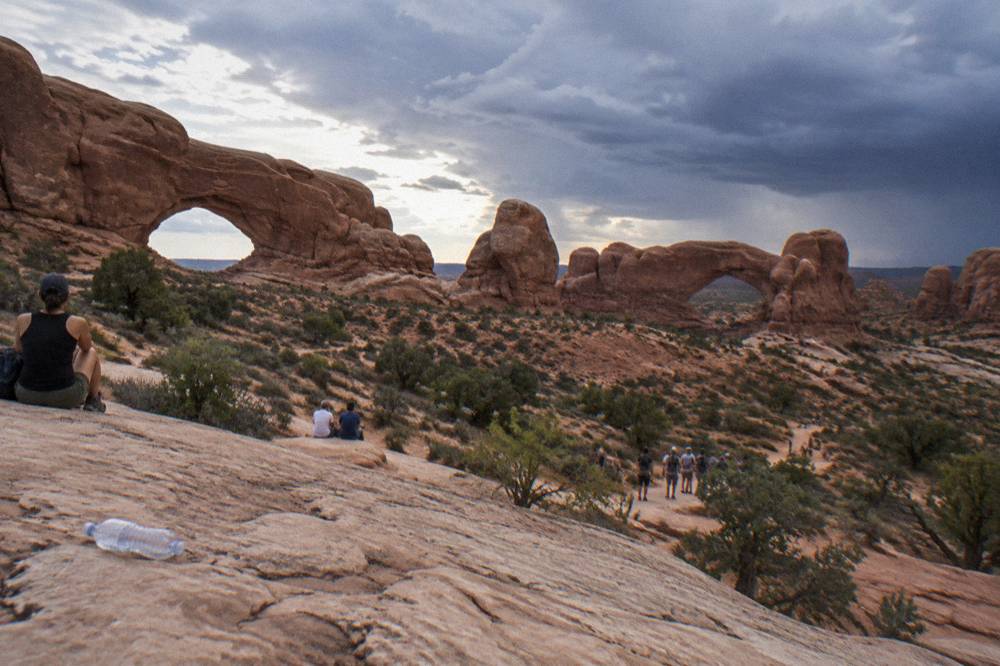 Visitors gathered on sandstone ledges viewing the North and South Window arches