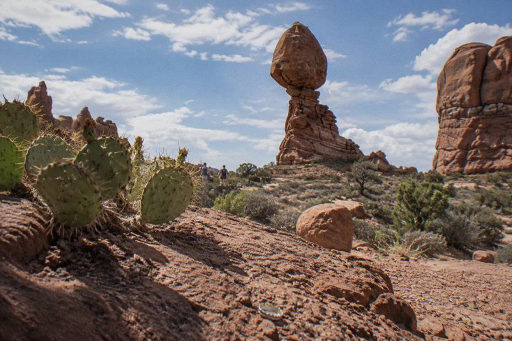 Sunlit sandstone fins and balanced rock formations under scattered clouds