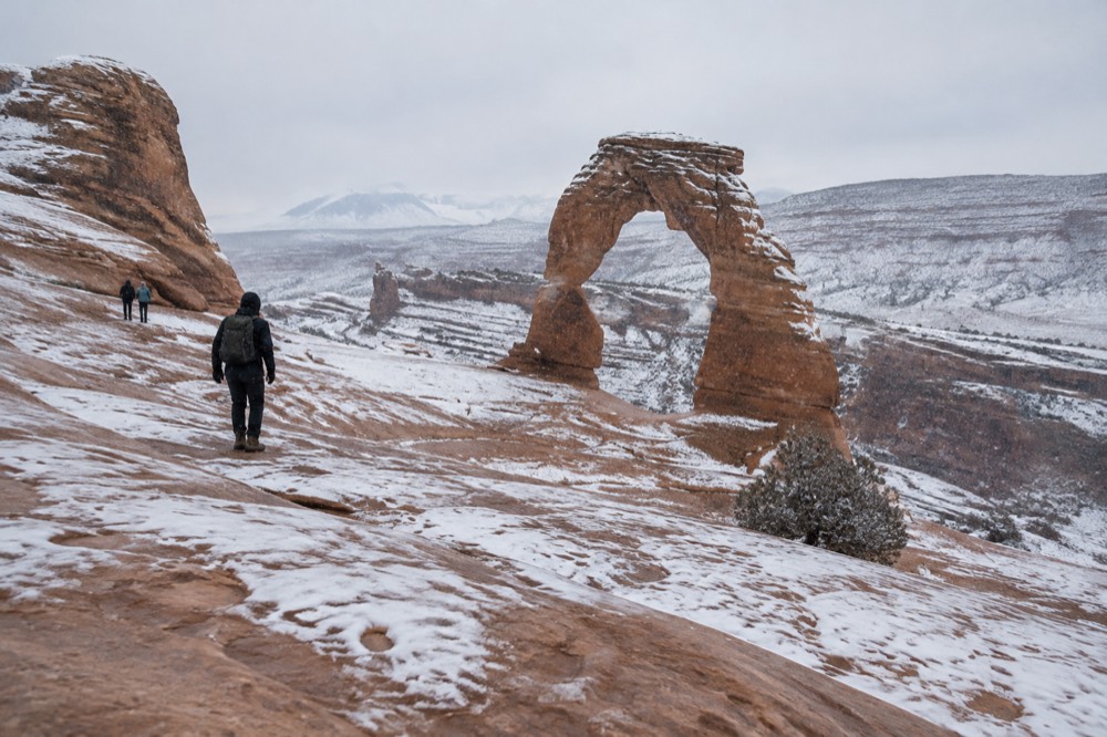 Dustings of snow on red sandstone arches under a pale winter sky