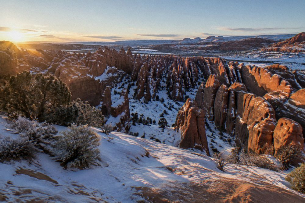 Long shadows across snow-dusted sandstone fins in cold morning light