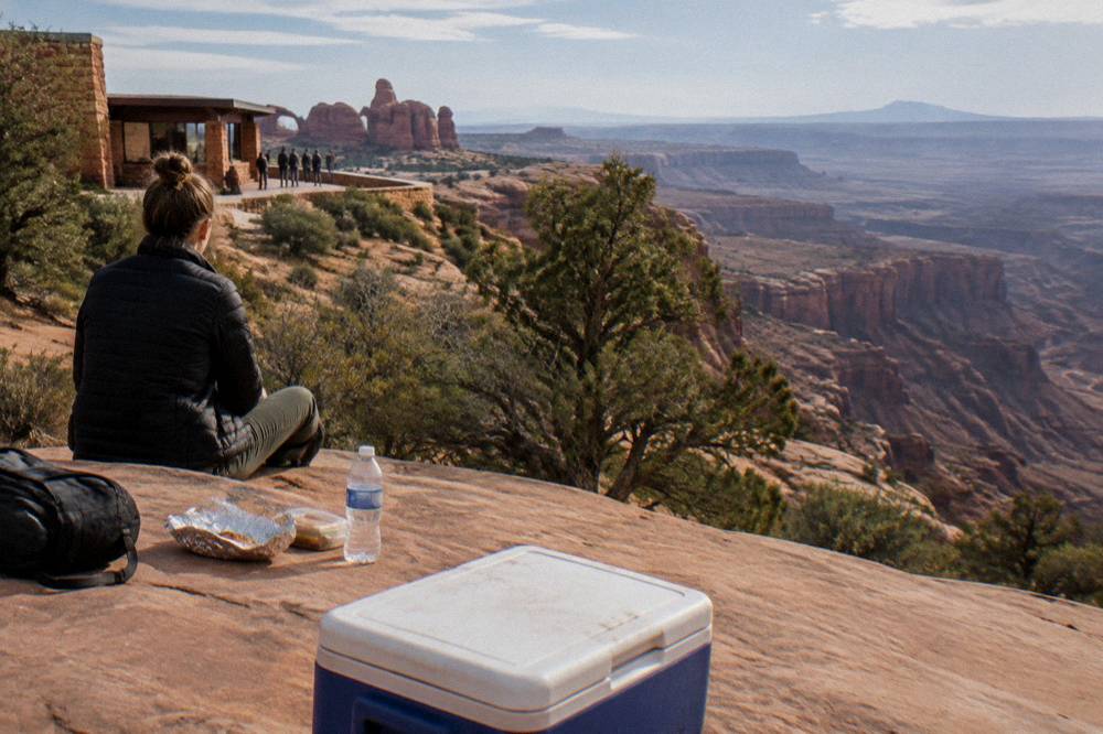 Picnic lunch laid out on a rock ledge above a wide canyon