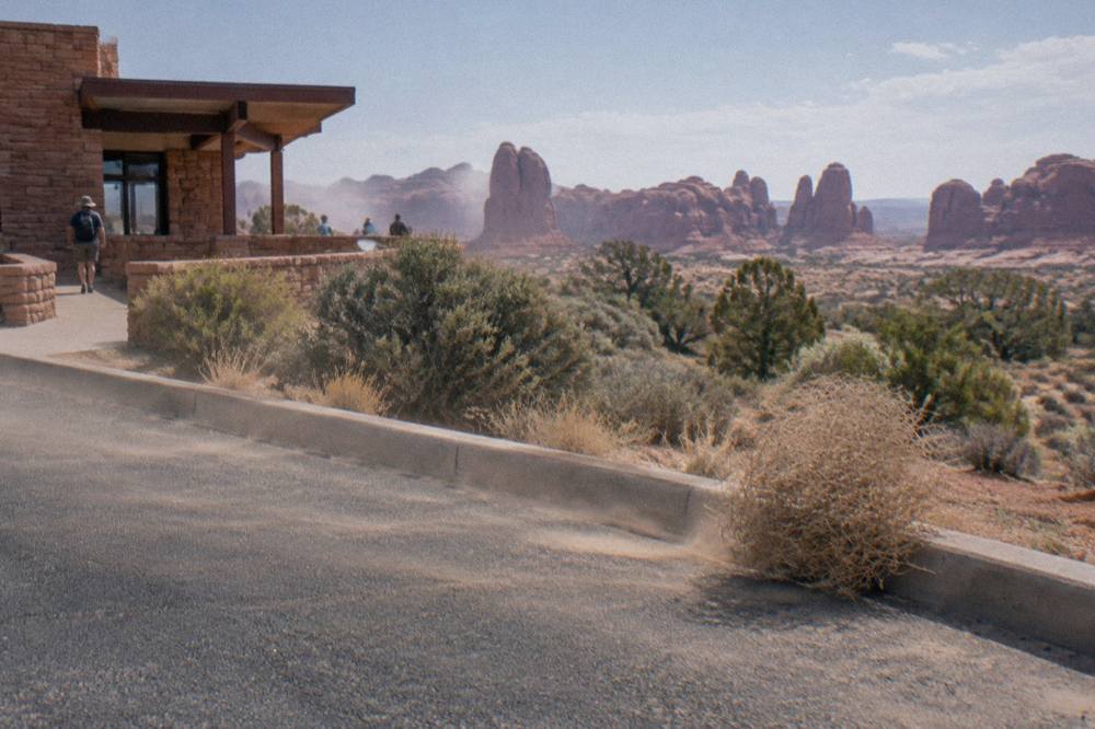 Red rock formations beside a paved pullout along the Arches park road