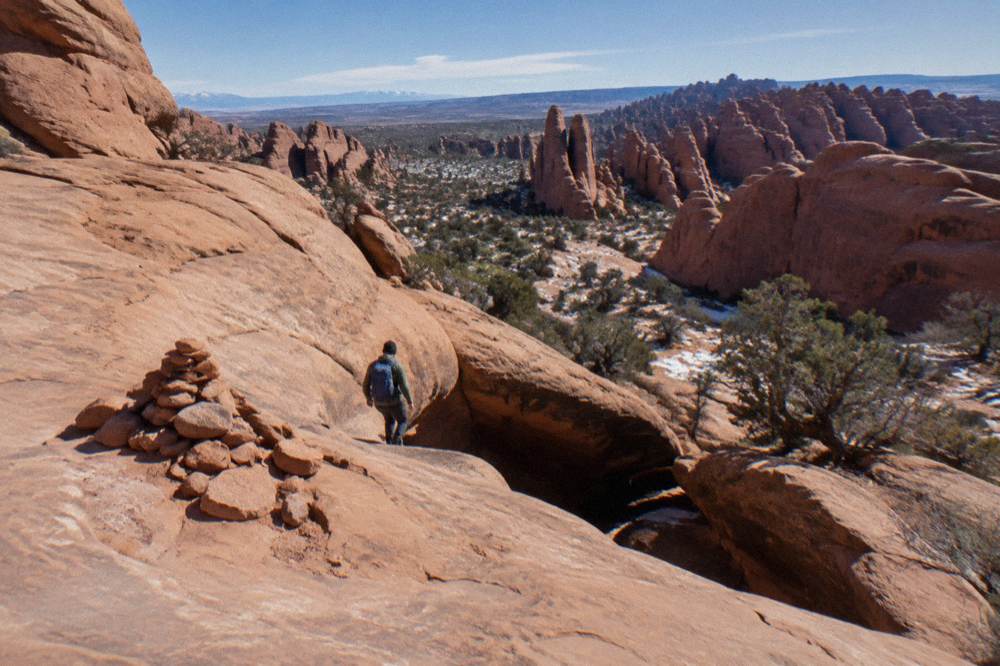 Smooth slickrock ledges and a small drop along an unmarked route