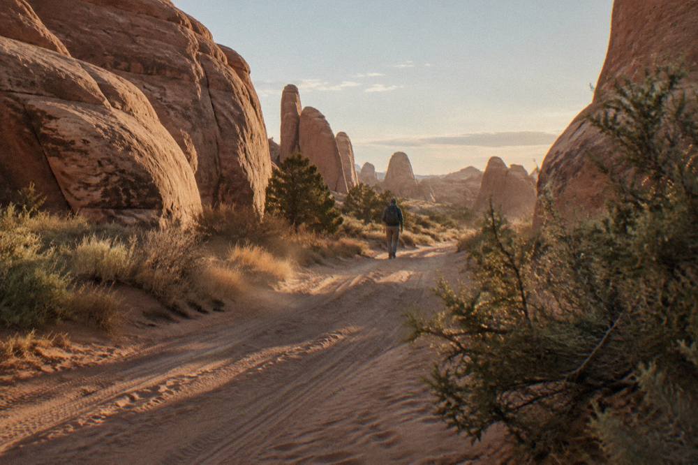 A four-wheel-drive track winding between tall red sandstone fins in the Arches backcountry