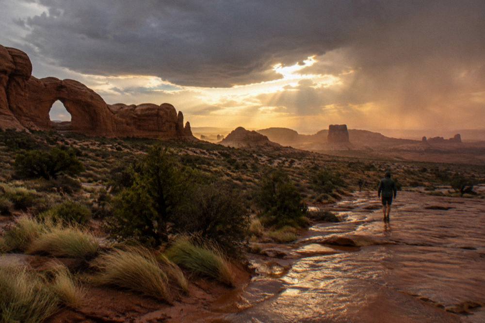 A wide desert panorama of arches and distant buttes under evening light