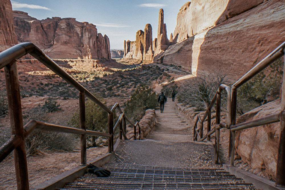 A red rock canyon wall with layered sandstone formations in morning light