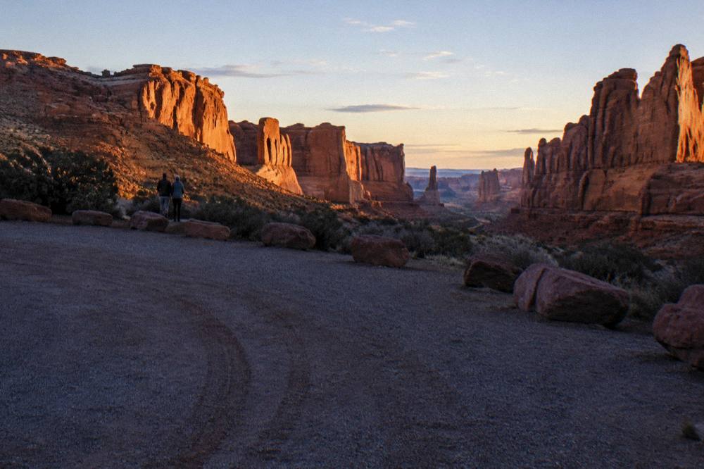 A quiet pullout along the park road with warm light on distant rock layers