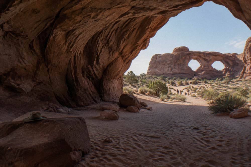Double Arch spanning a sandy clearing near the Windows section at late afternoon